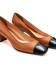 Zapatillas de piel con punta negra y tacón bajo para mujer